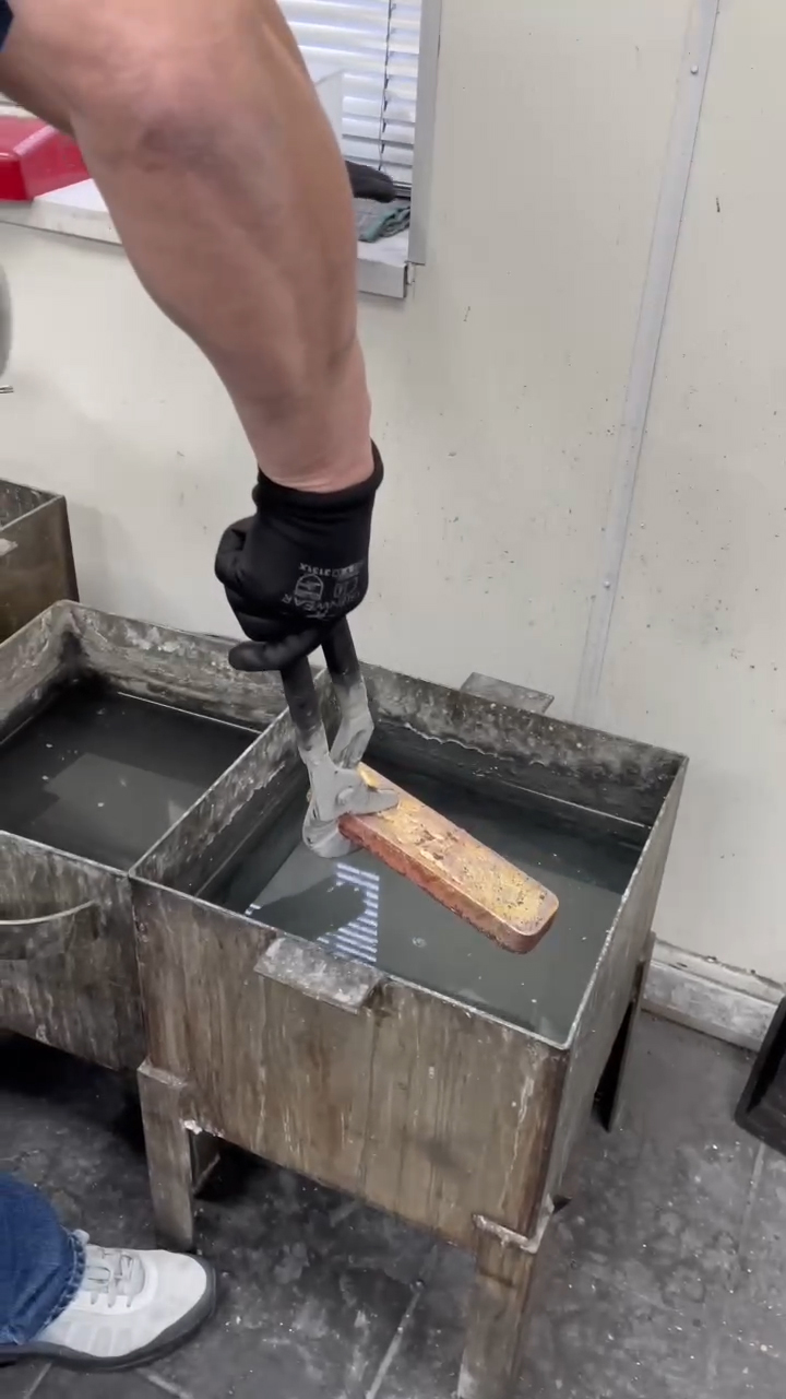 Using a wrench to carry a gold bar to the cooling bucket