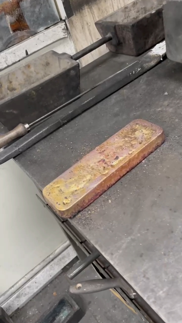 Cooled smelted gold bar resting on the table