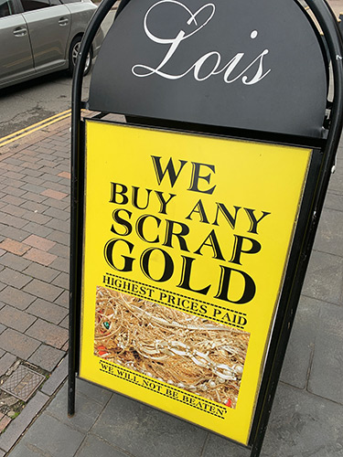 Lois Bullion shop sign reading 'We buy any scrap gold highest prices paid we will not be beaten.'