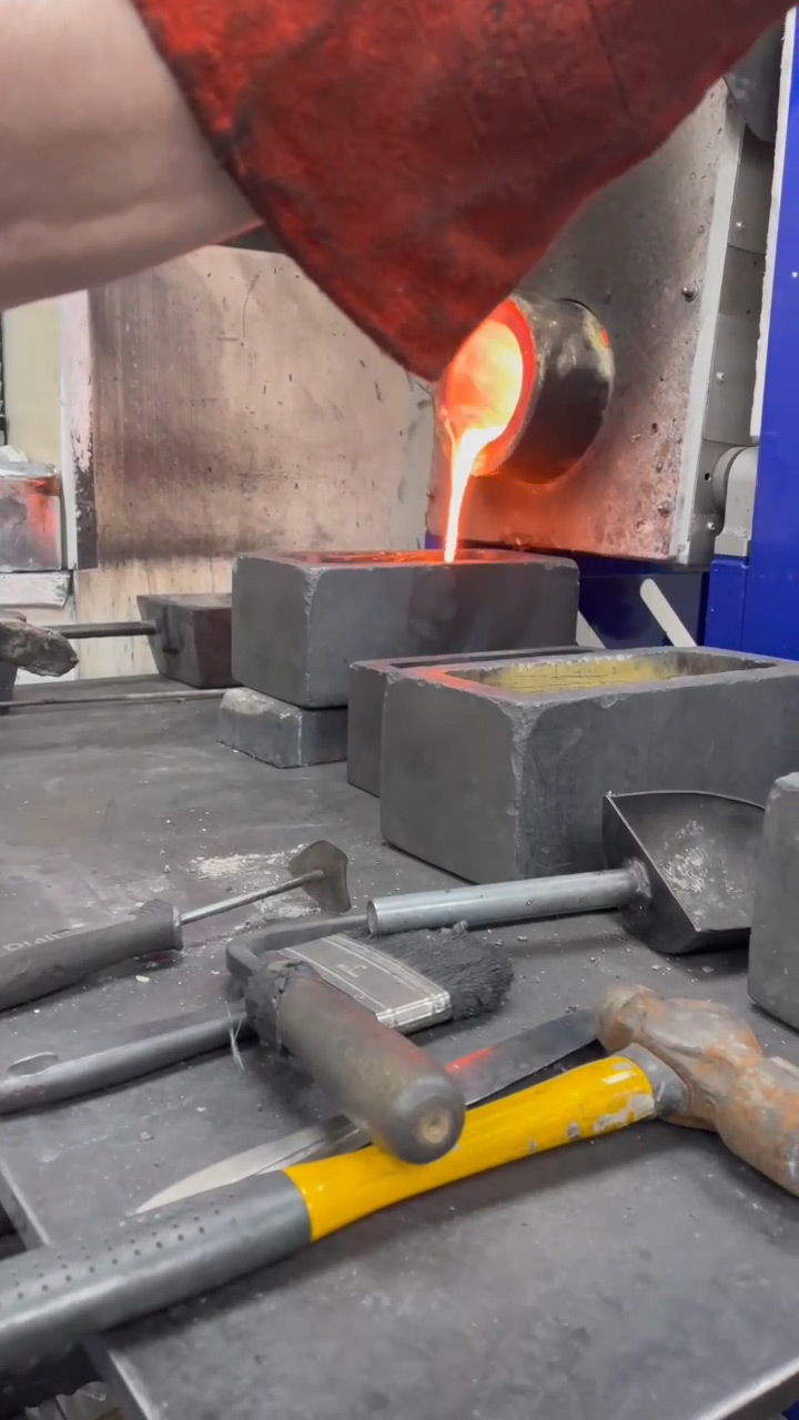 Molten gold flowing from the crucible into a 10kg bar mould