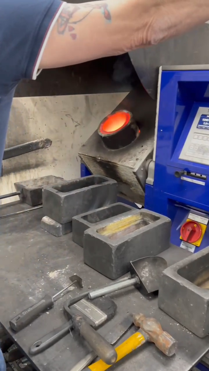 Tilting the crucible to pour molten gold into a mould