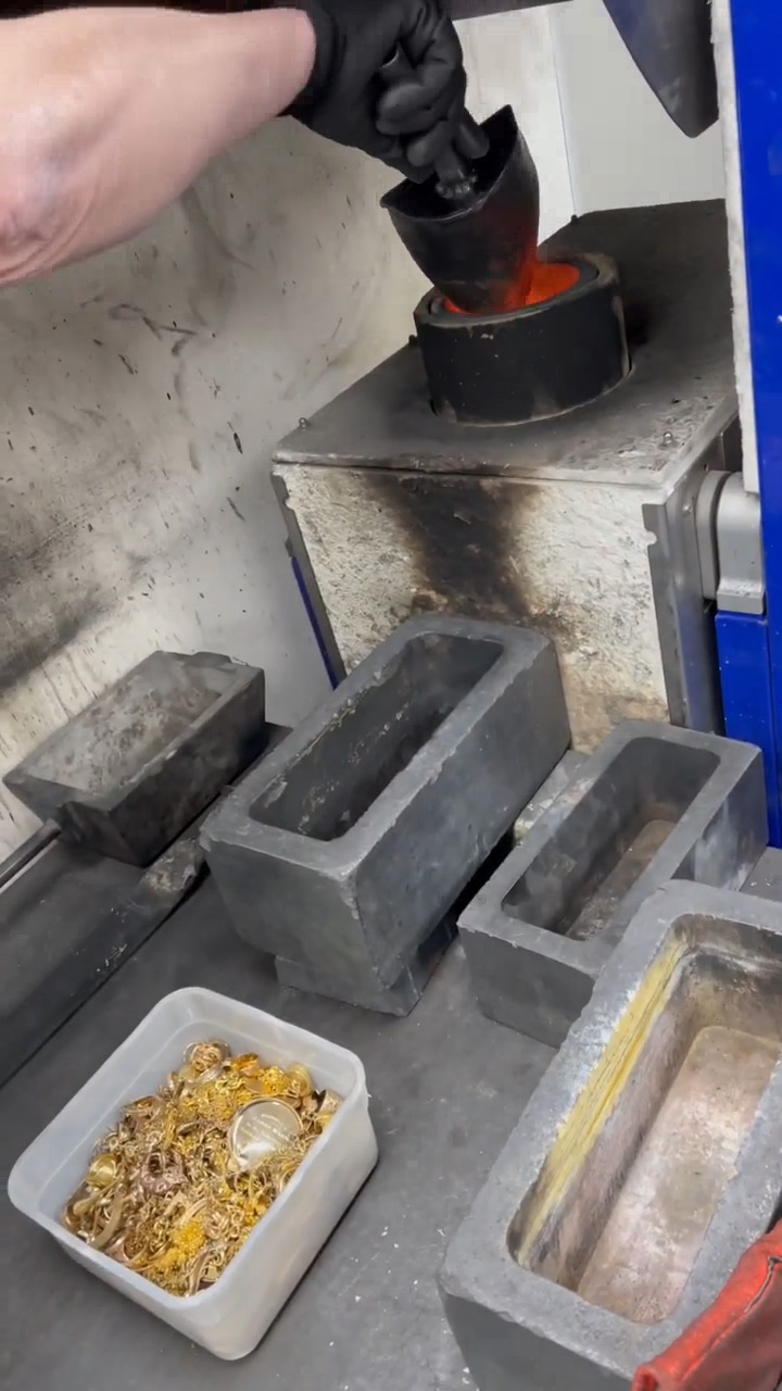 Pouring scrap gold jewellery into the top of a crucible